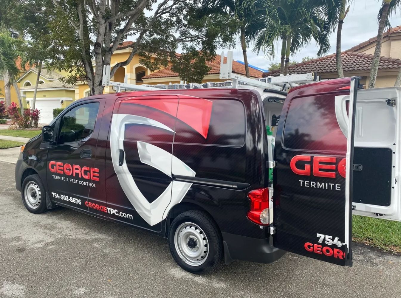 George Termite & Pest Control service van parked with rear door open in a residential neighborhood.