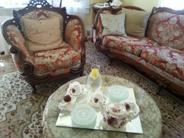 English sofa and chair with glass tables set up for tea