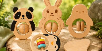 Wooden animal-shaped baby rattles on a wooden surface.