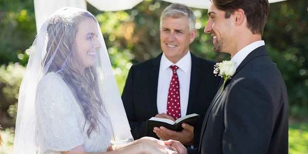 Bride and groom exchanging vows at outdoor wedding.