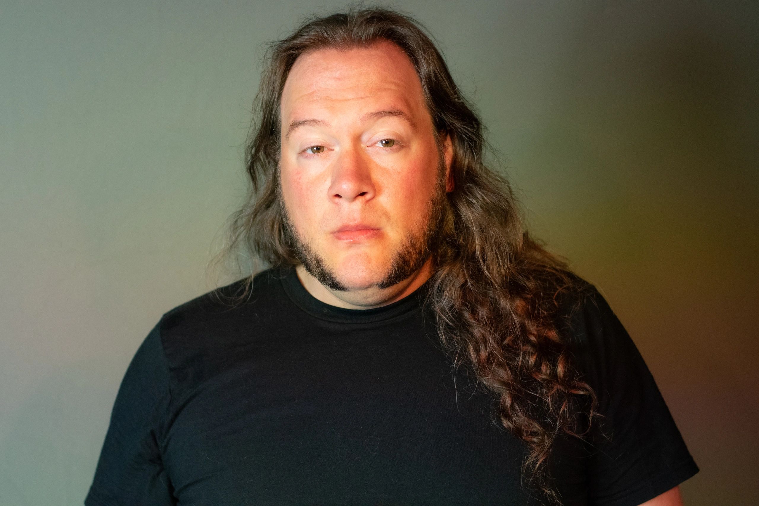 Portrait of a man with long hair and sideburns.