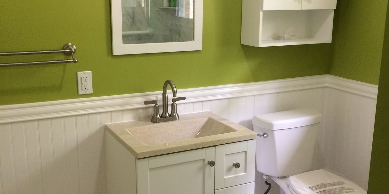 Bathroom with green walls and white fixtures.