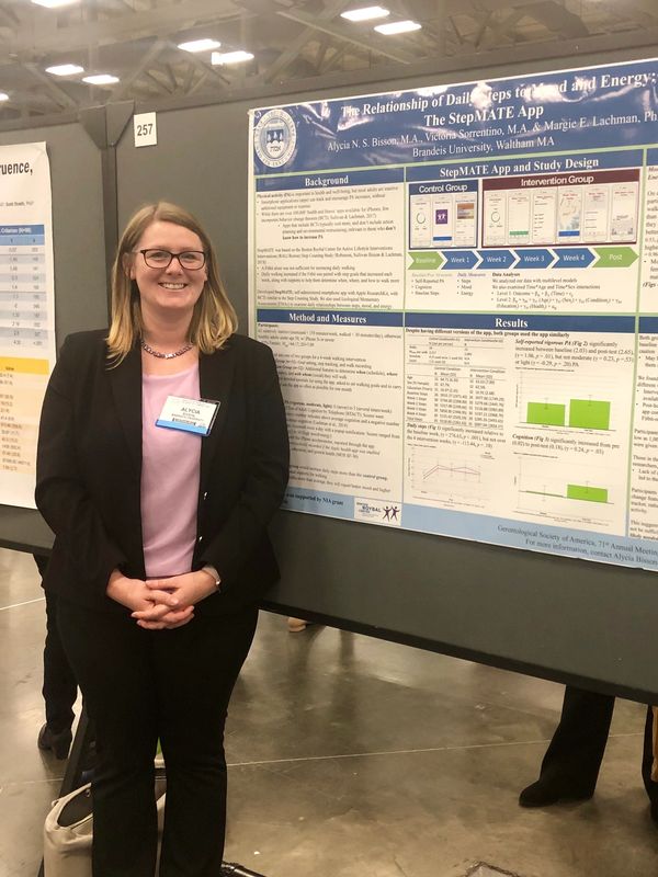 Photo of a woman standing in front of an academic poster. 