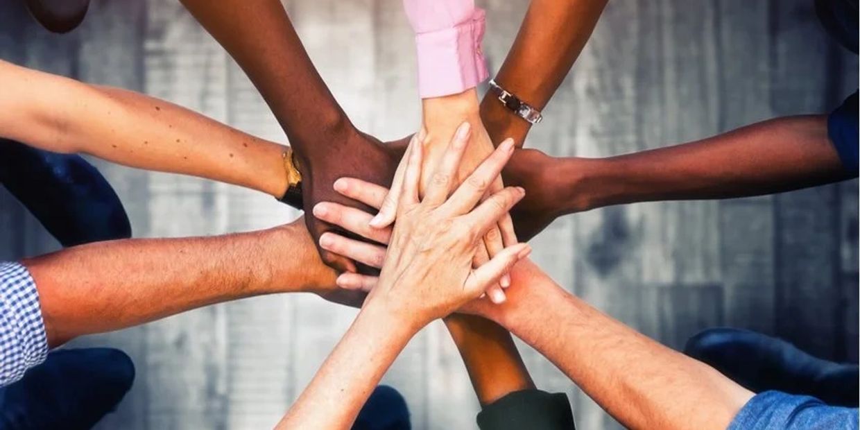 Diversity of hands embraced in a huddle
