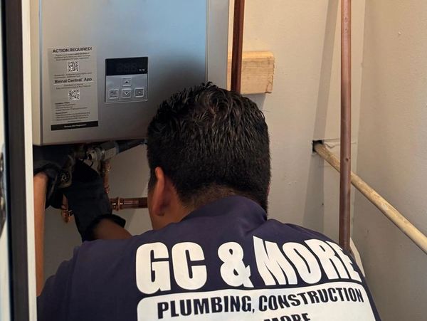 Plumber fixing a unit with GC &amp; More logo shirt.