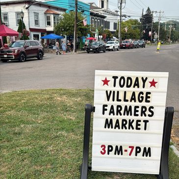 Sign announcing today's village farmers market from 3 PM to 7 PM.