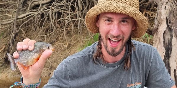 Smiling guy, very happy holding a piranha 