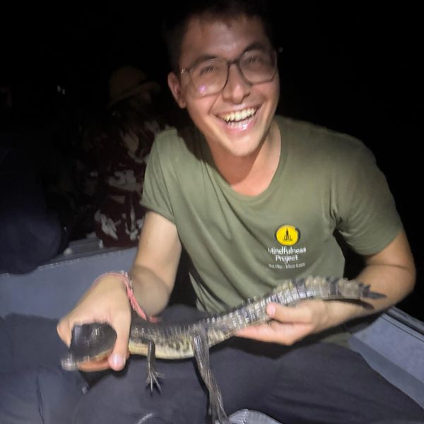 Very happy guy , smiling holding a baby alligator
