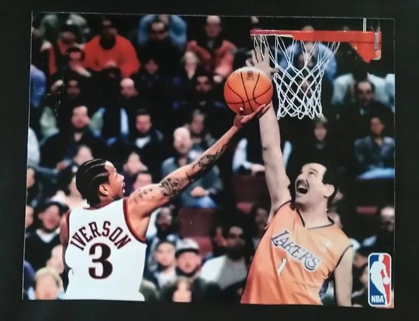 Allen Iverson blocks a Lakers player attempting a layup in an intense NBA moment.