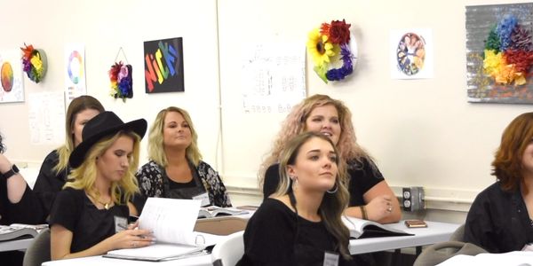 Women attentively listening in a classroom setting.
