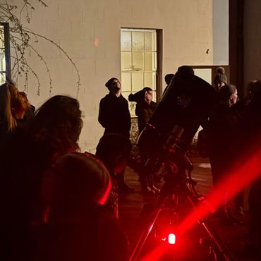 Group of people stargazing using telescopes at Lydiard Park Hotel