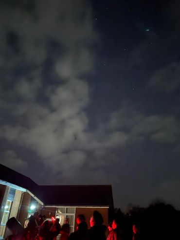 Night sky and people at public stargazing event
