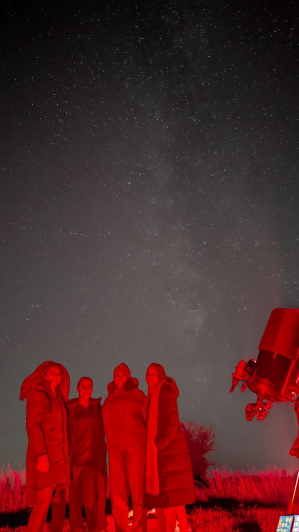 A group of 4 friends with NOVA's mobile observatory under the night sky in North Fawley