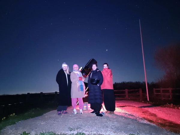 A family of 4 with NOVA's mobile observatory under the night sky in Leicestershire