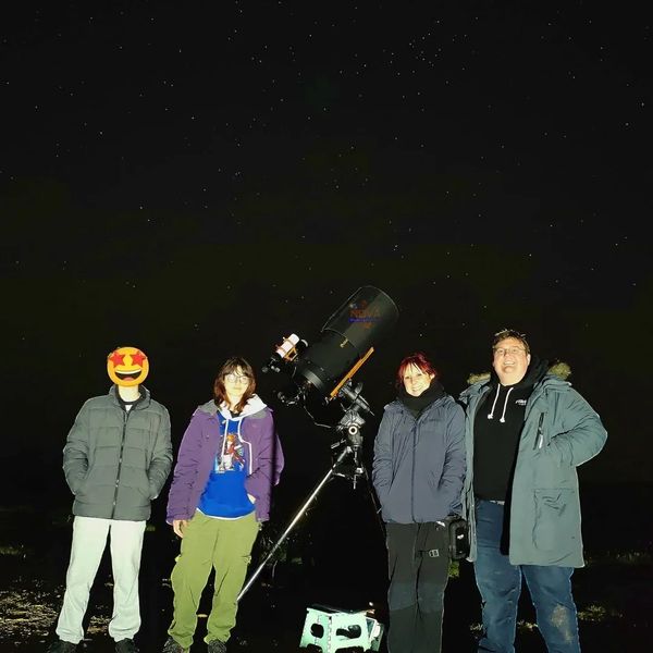 A family of 4 with NOVA's mobile observatory under the night sky in Brecon Beacons