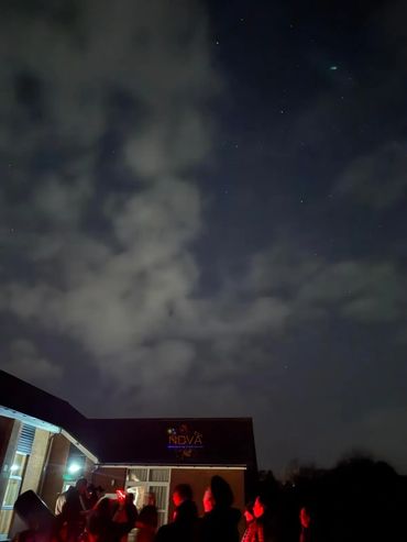 Night sky and people at public stargazing event