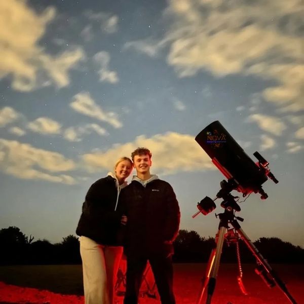 A young couple with NOVA's mobile observatory under the night sky in Lincolnshire
