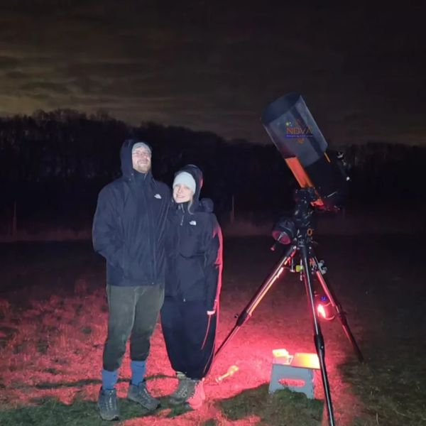 A couple next to NOVA's mobile observatory under the night sky in Northamptonshire