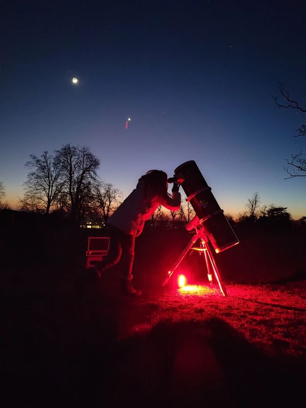 A woman looking through NOVA's mobile observatory 