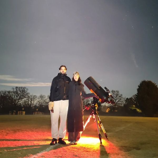 A lovely couple next to NOVA's mobile observatory under the night sky in the West Midlands