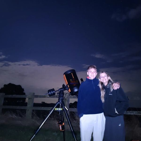 A young couple stood next to NOVA's mobile observatory under the night sky in Leicestershire