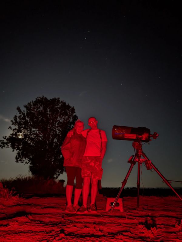 A couple with NOVA's mobile observatory under the night sky in Warwickshire