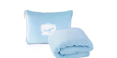 Light blue travel pillow and blanket set with airplane luggage design.
