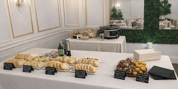Elegant buffet table with assorted breads, cookies, and condiments in a classy dining room.