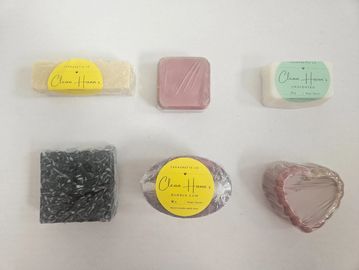Assorted handmade soaps wrapped in plastic with colorful labels from Clean Hann's.