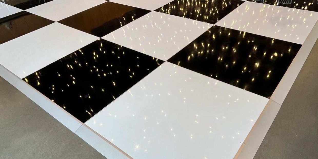 Shiny black and white checkered floor reflecting lights.
