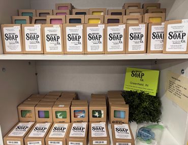 Shelves filled with boxed handmade soaps in various scents and colors.