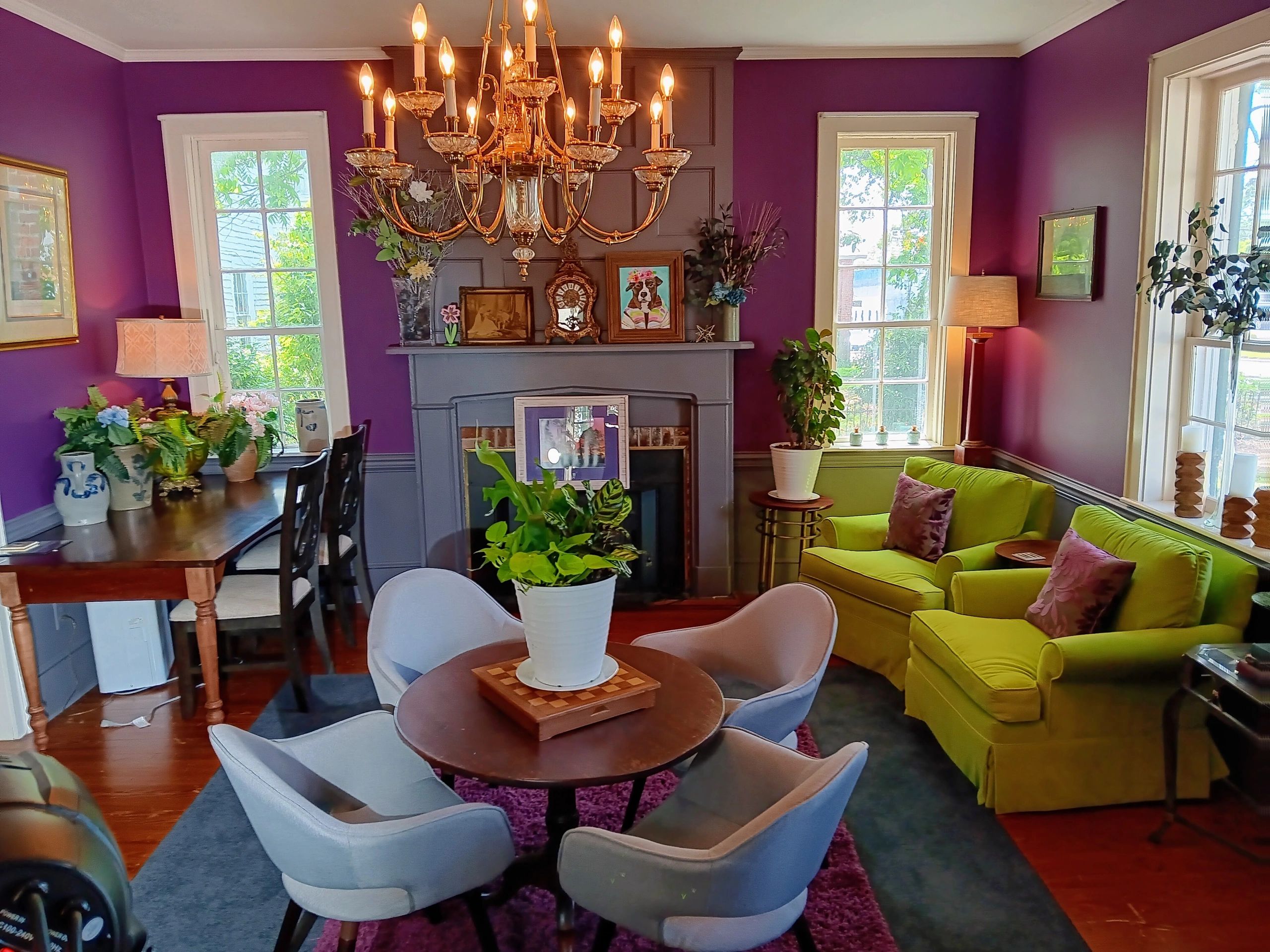 Cozy living room with purple walls, green sofa, and elegant chandelier.