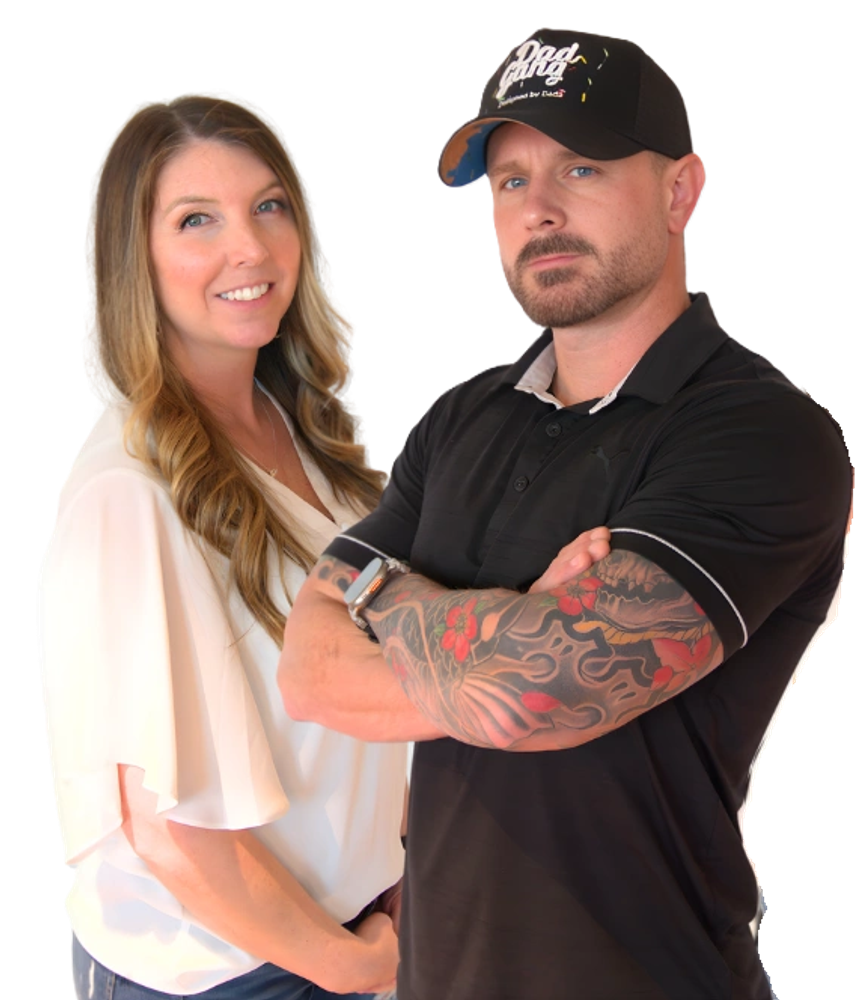 A couple,  one woman and one man with tattoos and a cap, smiling and posing.