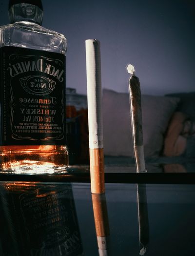 A cigarette stick and a bottle of alcohol 