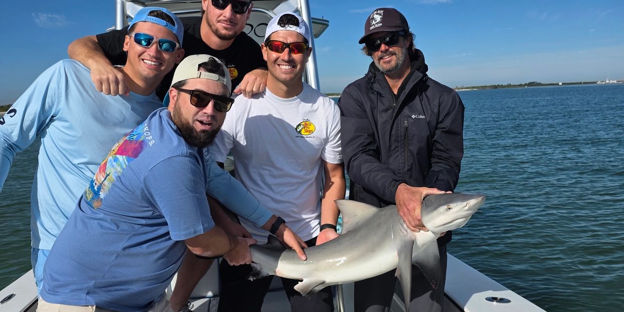 Clients with a bull shark while shark fishing here in daytona beach