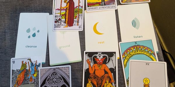 A spread of tarot and oracle cards with various symbols and illustrations.