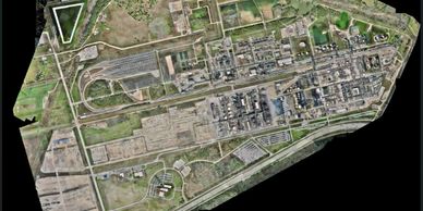 Aerial view of a large industrial complex with various buildings and railway tracks.