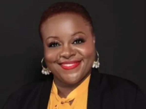 A woman speaker in yellow color dress and a black coat 
