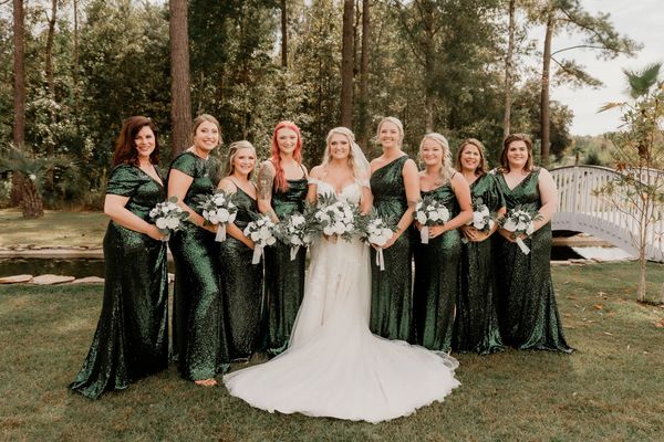 Bridesmaids in green dresses with bride on wedding day with elegant hair and makeup in Georgia.
