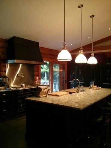 Cozy kitchen with granite island and pendant lights.