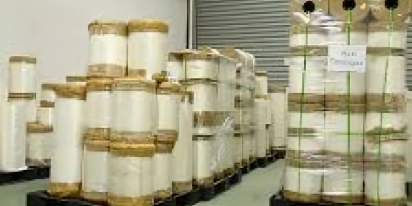 Warehouse stacks of large white rolls.
