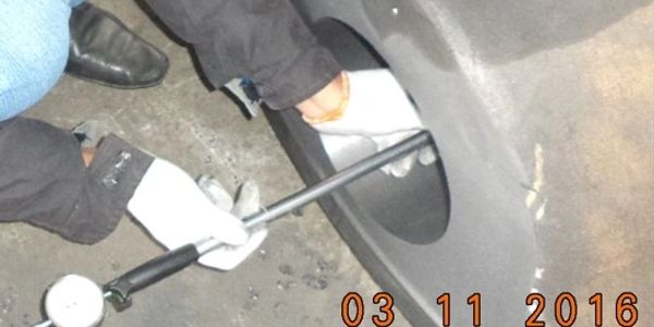 Person using a tool to check or repair a tire on a vehicle.