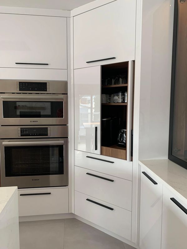 Cuisine moderne avec électroménagers intégrés et placards blancs.