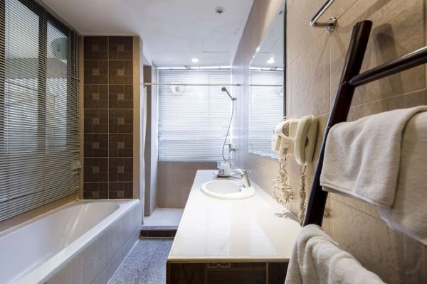 Modern bathroom with bathtub and countertop sink.