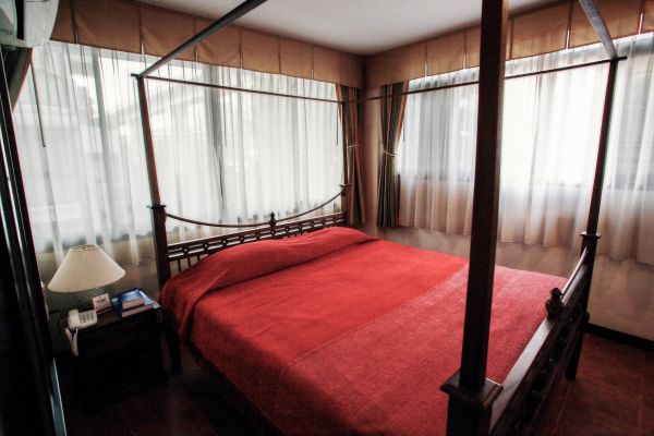 Cozy bedroom with a four-poster bed and red bedspread.