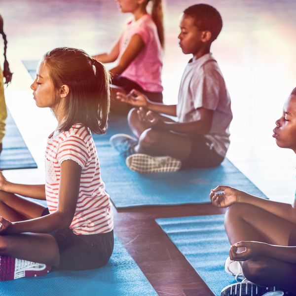 Children meditating on yoga mats in a calm setting.