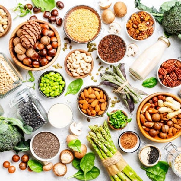 Various healthy nuts, seeds, and vegetables arranged artistically.