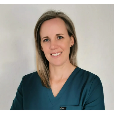 Smiling woman in teal medical scrubs against a plain background.