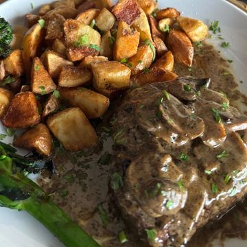 Steak with mushroom sauce, roasted potatoes, and asparagus.