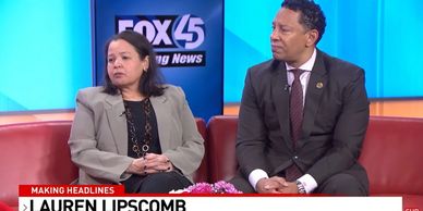 Two news anchors seated on a red couch during a Fox 45 segment.